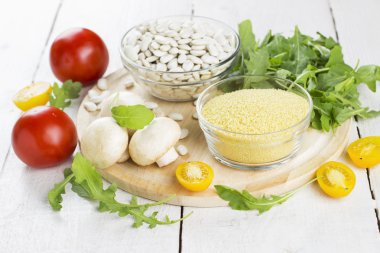 Kuru, mantar, roka ve domates ahşap arka plan üzerinde kuskus için malzemeler