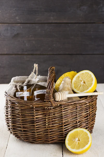 Lemon, ginger, honey in wattled basket on a wooden background 
