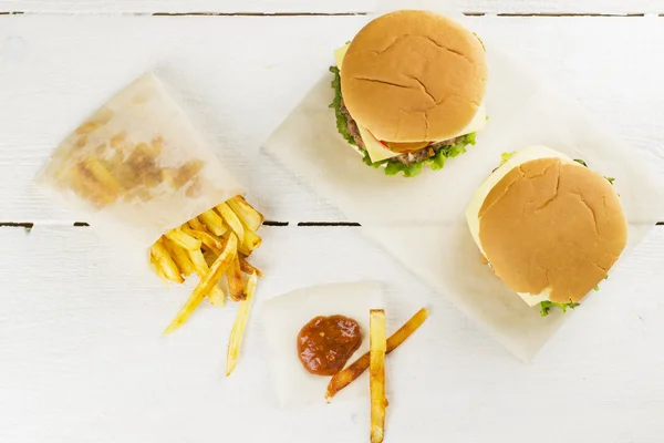 Patates kızartması ve ketçap bir beyaz tahta arka plan ile Mini hamburger. Üstten Görünüm
