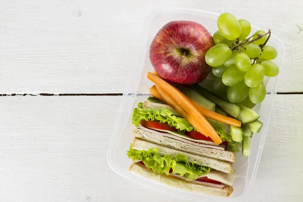 Lunchbox with sandwich, vegetables, fruit on white background. Top view — Stock Photo, Image