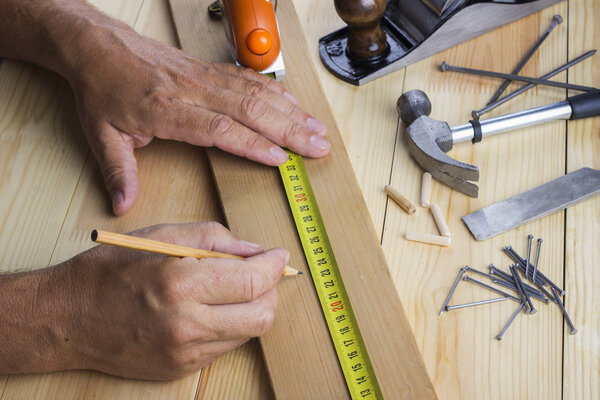 The man measures plate on a table with various accessories to repair