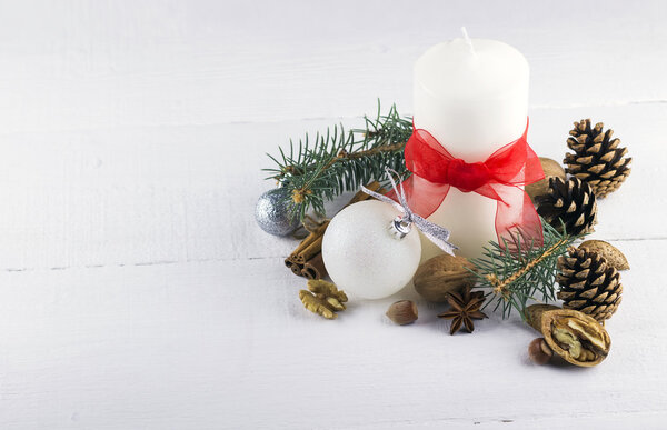 Праздничные свечи, ель, сосновые шишки, орехи на деревянной спинке
