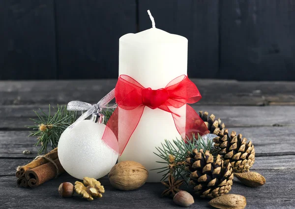 Velas festivas, abeto, cones de pinheiro, nozes em um contexto de madeira — Fotografia de Stock