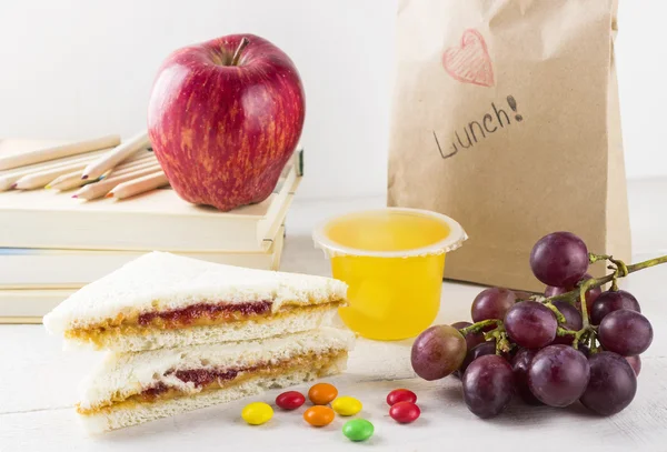 Lunchbox in school: sandwich with peanut butter and jam, apple, jelly — Stock Photo, Image