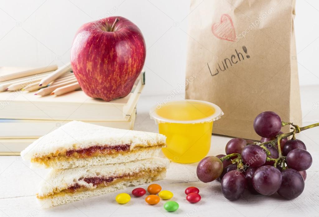 Lunchbox in school: sandwich with peanut butter and jam, apple, jelly