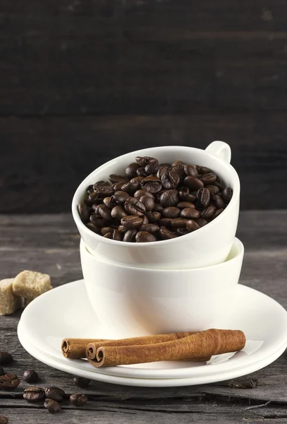 Koffie granen, suiker, kaneel op donkere houten achtergrond — Stockfoto