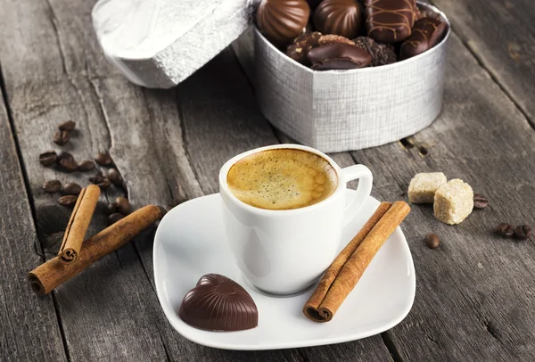 Doos bonbons, kopje koffie op een houten achtergrond — Stockfoto