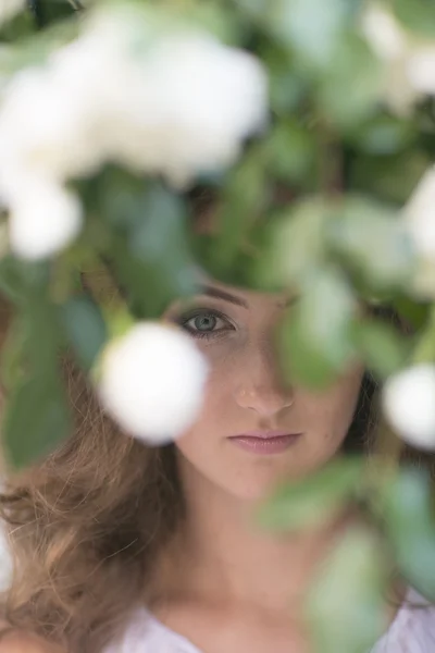 Visage féminin parmi les fleurs — Photo