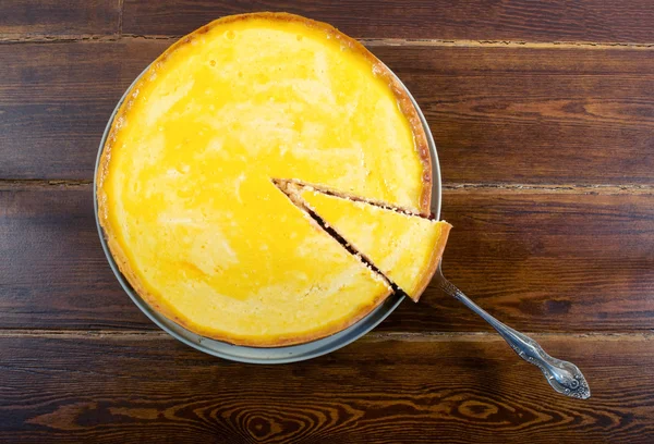 Круглый сырный торт вид сверху с лопаткой — стоковое фото