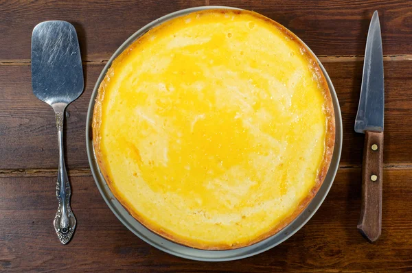 Круглый сырный торт вид сверху с лопаткой и ножом — стоковое фото