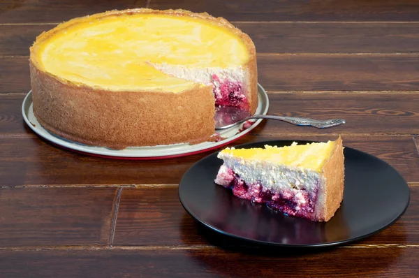 Round cheese cake with piece — Stock Photo, Image