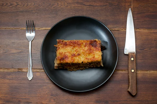 Piece of lasagna with tableware — Stock Photo, Image