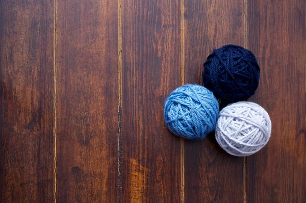 Three skeins in blue tones over wooden background — Stock Photo, Image