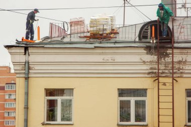 İnşaat işçileri, yirminci yüzyılın dış cephesinde büyük onarımlar yapmaya çalışıyorlar.