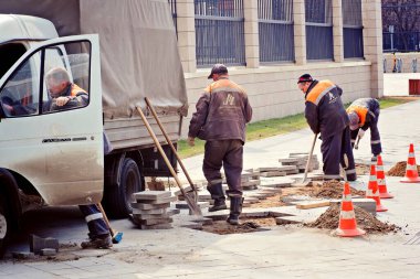 İnşaat işçileri bazı nedenlerden dolayı hala oldukça sağlam kiremitleri seçip kırıyorlar.