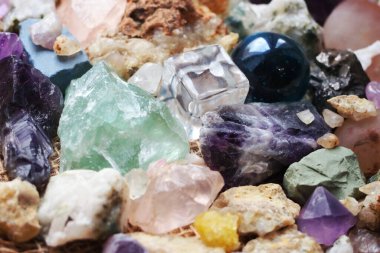Şeffaf plastikten yapılmış bir kübik figür ve fosillerin yanında camdan yapılmış bir top figürü ve çeşitli kayaların mineralleri.