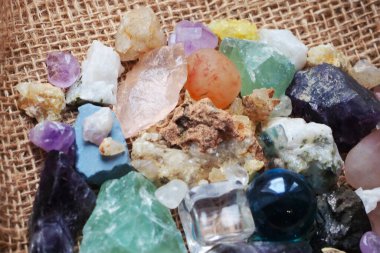 Şeffaf plastikten yapılmış bir kübik figür ve fosillerin yanında camdan yapılmış bir top figürü ve çeşitli kayaların mineralleri.