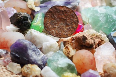 Çeşitli kayaların fosil değerli taş ve mineralleri üzerinde ve yakınında deforme olmuş antik madeni paralar.