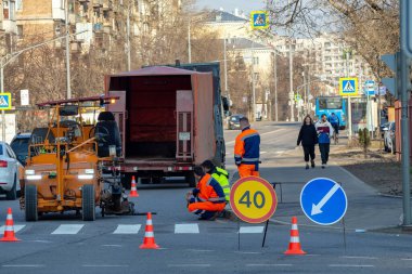 Yol işçileri kavşağın yanındaki virajda mevsimsel onarım sorunlarını hallediyorlar.