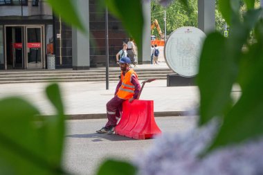 İnşaatçı, arabalardan tamir edilecek yolu koruyor.
