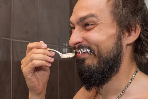 Homem Barbudo Come Creme Azedo Enquanto Mancha Bigode Com Ele — Fotografia de Stock