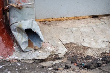 Atık su borusu parçası olan bir evin yakınındaki bir çöp yığını.