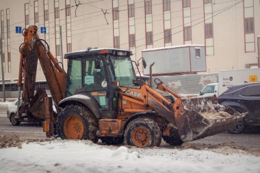 Buldozer kazıcısı, kış mevsiminde karla kaplı sokaklar