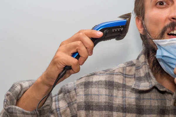 髭の男は電気ヘアクリップで剃ろうとします — ストック写真