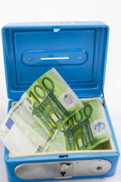 Hromádky mincí a bankovek v hotovosti box — Stock fotografie
