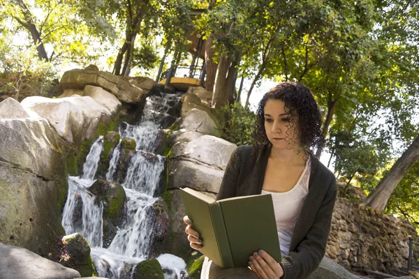 Genç kadın sonbaharda bir kitap okuma