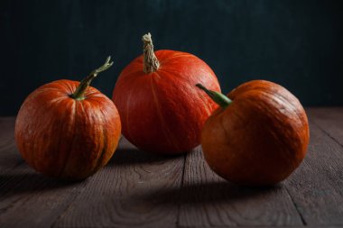 Ahşap masadaki balkabakları karanlık bir ruh halinde.