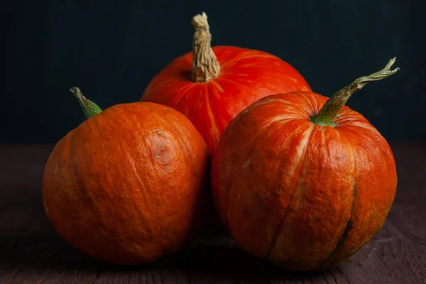 Pumpkins on wooden table in dark mood. — Stock Photo, Image