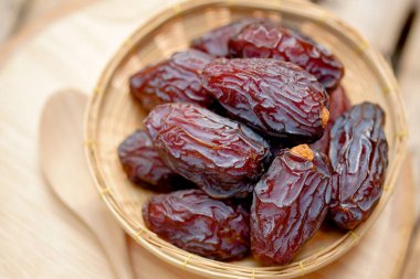 Medjool, masadaki ahşap sepetteki meyvelerin tarihlerini ya da tarihlerini gösterir. Emziren anneler için besleyici meyveler anne sütünü arttırır.