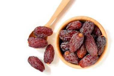 Medjool tarihleri veya tarihleri ahşap fincanlar ve kaşıklar beyaz arkaplan, üst görünüm izole.