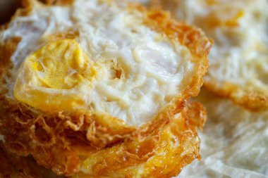 Yemek tepsisinin üstüne konmuş yumurta çok yağlıdır. Bu da Tayland 'da popüler bir yemektir..