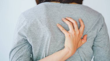 Sırtını kaşıyan bir kadın alerjik reaksiyon yaşıyor ya da bir böcek tarafından sokuluyor. Deri hastalığı kavramı.