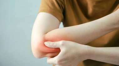 Dirsek ağrısı çeken, kırmızı çizgili iltihap alan, eklem ağrısı ya da kas zorlanması çeken biri. Kol rahatsızlığı, sağlık konsepti, eklem iltihabı, tendonit ve vücut ağrısı tedavisi.
