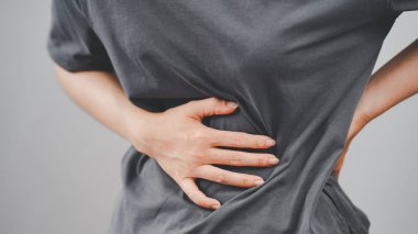 Acı çeken, muhtemelen böbrek sorunları, kas zorlanması ya da regl sancısı çeken fiziksel sağlık sorunlarını ve rahatsızlığı temsil eden kadınların yakın çekimi..