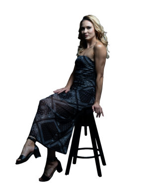 Elbiseli kadın zarif bir şekilde taburede oturuyor.