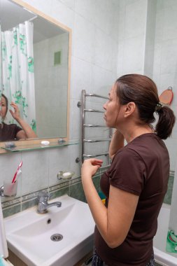 Banyoda bir kız sabah rutinini yapıyor.