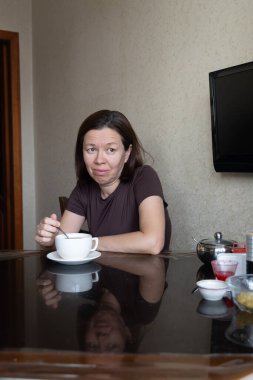 Güzel bir kızın portresi. Sabahları mutfakta bir fincan kahveyle.