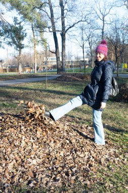 Genç kız parkta vakit geçiriyor.