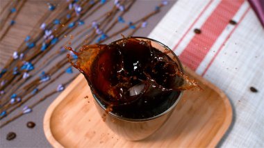  Su damlatan buz küpü bir fincan kahveye dökülüyor.