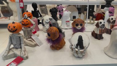 Riga, Letonya - 19 Eylül 2025: Cadılar Bayramı dekoratif heykelciklerinin canlı bir koleksiyonu, balkabağı kafalı iskeletler ve neşeli hayvanlar da dahil, festival perakende ortamında sergilendi