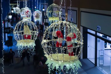 Tatil süslemelerinde, şeker kamışlarıyla aydınlatılmış büyük süsler sergileniyor, alışveriş merkezinin hareketli atmosferini artırıyor.