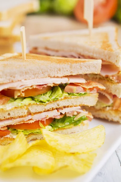 Club-Sandwich auf rustikalem Tisch im hellen Licht — Stockfoto