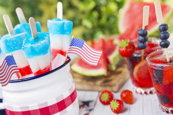 Red-white-and-blue popsicles on an outdoor table with summer dri