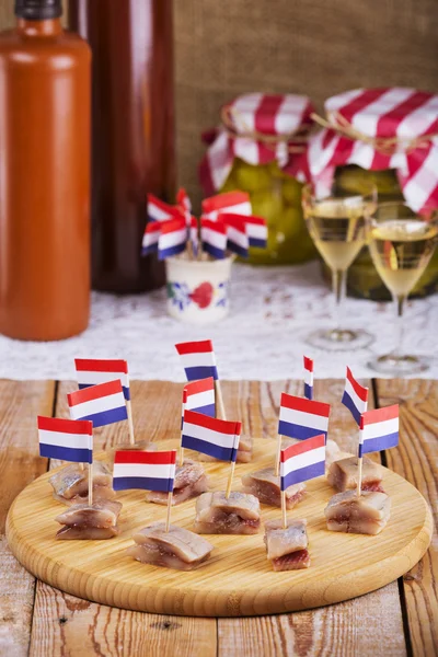 Nederlandse haring ('haring') met uien en pickles op rustieke tafel — Stockfoto