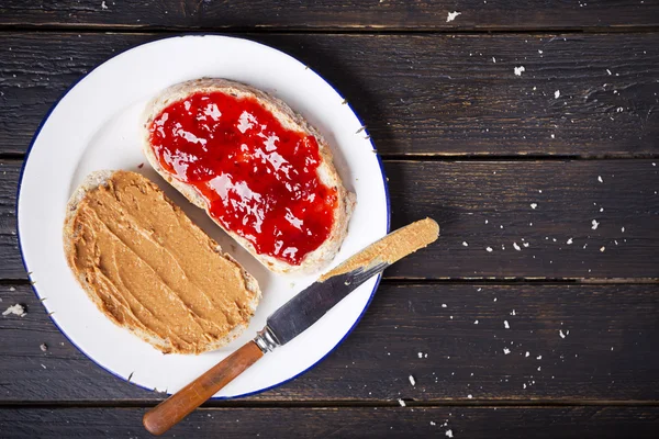 Sandwich de mantequilla de maní y jalea en una mesa rústica — Foto de Stock