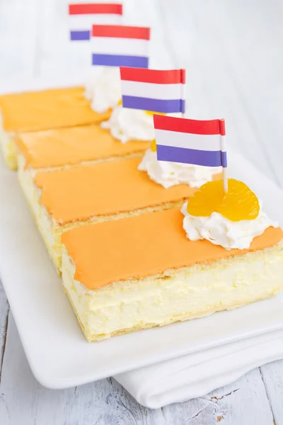 Oranje tompouce, traditionele Nederlandse gebak, op een rustieke tafel — Stockfoto